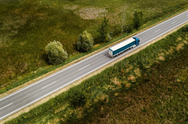 Lastkraftwagen mit Umzugskartons fährt auf einer Landstraße nach Dachau