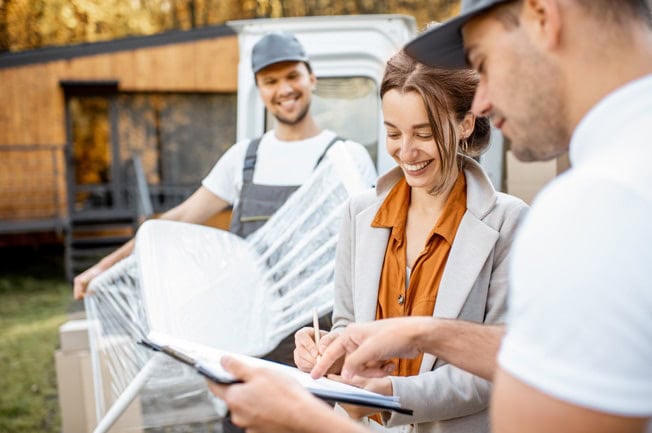 Eine Frau unterschreibt glücklich Umzugsunterlagen für einen Umzug nach Dachau
